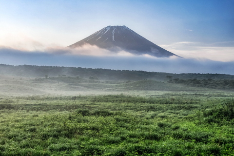 霧と雲流れる高原からの富士山