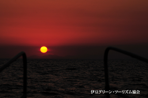 沈む夕陽を海の上から