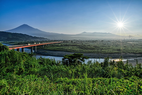 富士川からの朝日を浴びる街と富士の風景