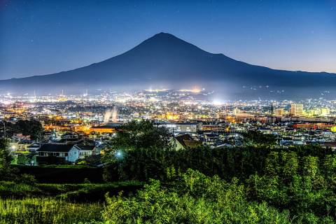 きらめく夜明けの街と富士山