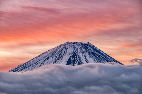 押し寄せる雲に浮かぶ富士と朝焼け