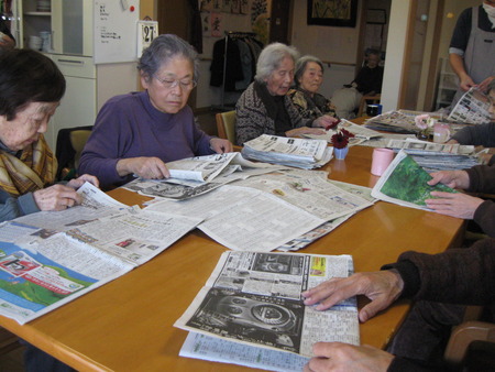 皆さんで排泄介助で使用する新聞をたたんでもらっています