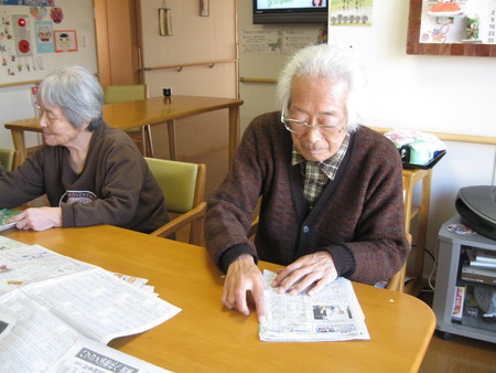 皆さんで排泄介助で使用する新聞をたたんでもらっています
