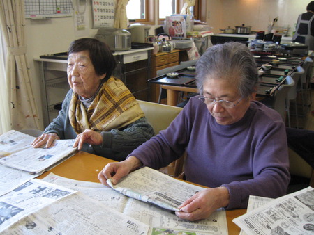 皆さんで排泄介助で使用する新聞をたたんでもらっています