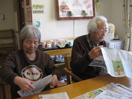皆さんで排泄介助で使用する新聞をたたんでもらっています