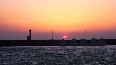荒れる港沖　夕陽が艶やかー